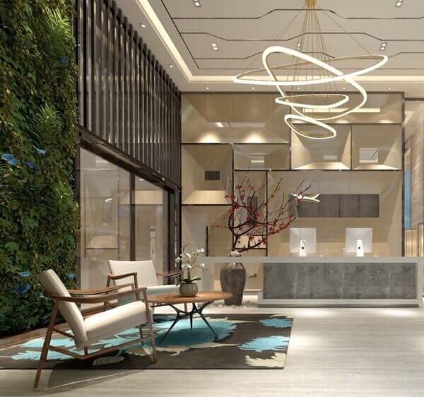 interior design of a modern hotel lobby with a faux plant wall and circular ring chandelier